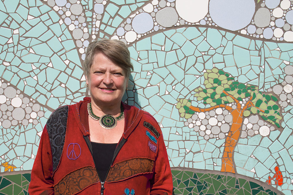 photo: Di Brandt standing in front of a mural